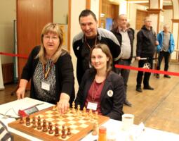 Die Thüringer Schachbund-Präsidentin Diana Skibbe führt den symbolischen ersten Zug am Brett von Josefine Heinemann aus. Dahinter Turnierdirektor Bernd Vökler.